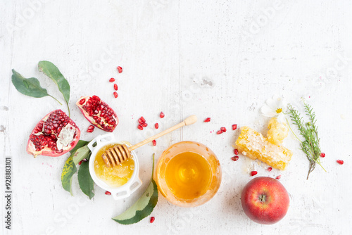 rosh hashana holiday - honey with apple and pomergranate over white desk background. border with copy space photo