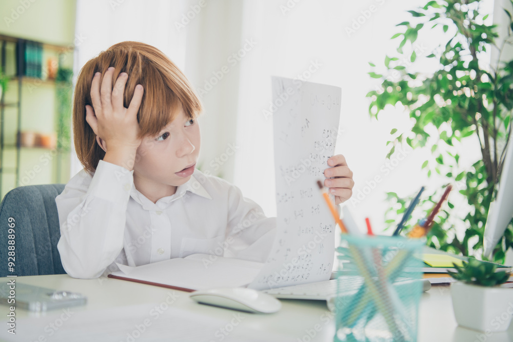 Portrait of cute smart clever intelligent learner boy sitting table doing hometask remote lesson room flat indoors Portrait of cute smart clever intelligent learner boy sitting table doing hometask remote lesson room flat indoors