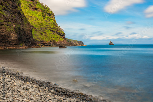 Baía de Alagoa on the island of Ilha das Flores, Azores, Portugal. Atlantic ocean coastline. Stones, rocks and water in long exposure. Nature photography in motion. photo