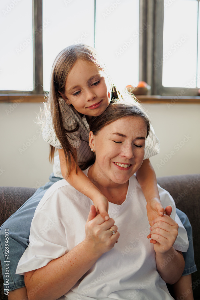 Smiling mother holding hands of daughter at home Smiling mother holding hands of daughter at home