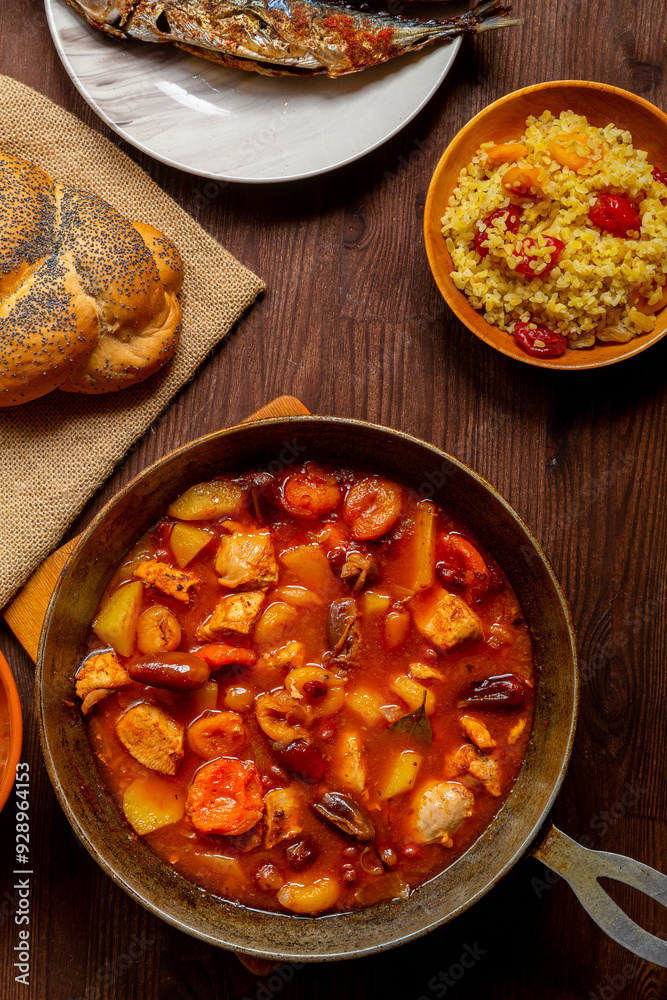 Hot cholent in a cast iron pan on the festive table for the Rosh Hashanah meal Hot cholent in a cast iron pan on the festive table for the Rosh Hashanah meal
