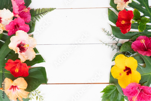 Tropical flowers and leaves on wooden background, summer vacational background photo