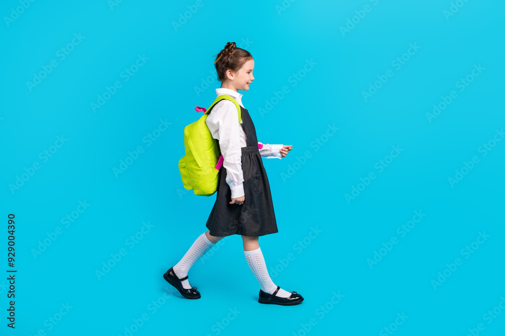 Full body photo of cute little girl backpack shopping profile walking dressed stylish school uniform isolated on blue color background Full body photo of cute little girl backpack shopping profile walking dressed stylish school uniform isolated on blue color background