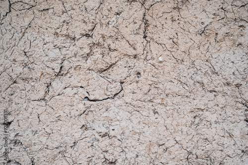 Old cracked wall made of orange clay and straw.