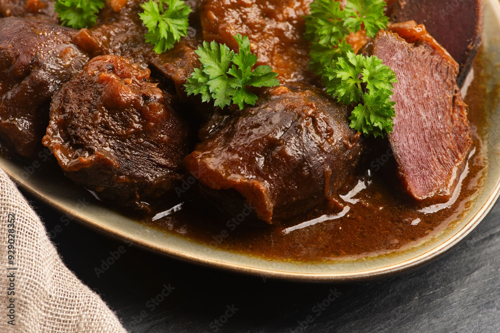 Stewed goose stomach. Traditional Polish meat on a dark background. Stewed goose stomach. Traditional Polish meat on a dark background.