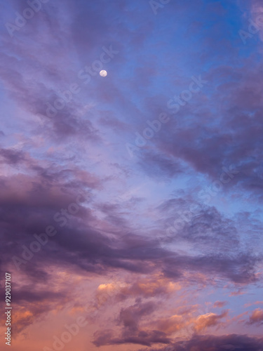 Dramatic Gradient Bluen Orange and Purple Sky with Clouds and a small Moon photo