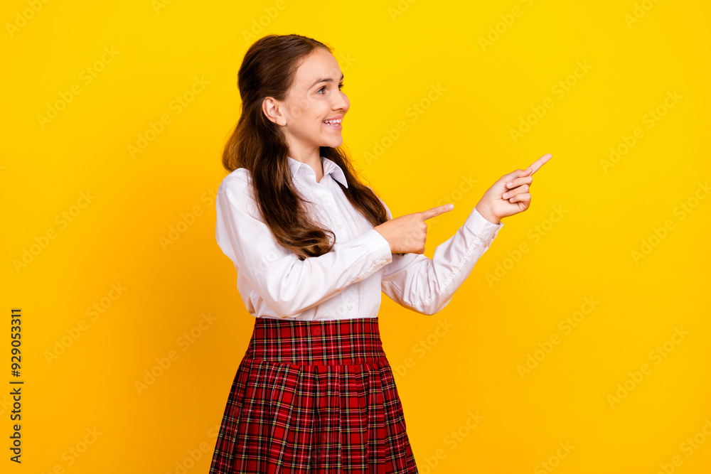 Photo portrait of cute teen schoolgirl diligent point look empty space dressed stylish uniform isolated on yellow color background Photo portrait of cute teen schoolgirl diligent point look empty space dressed stylish uniform isolated on yellow color background