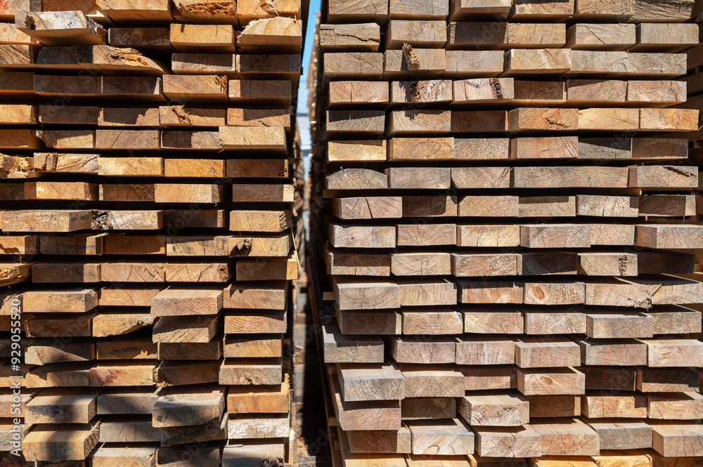 Fototapeta premium Stacked wooden planks close-up at lumber warehouse. Wood industry concept