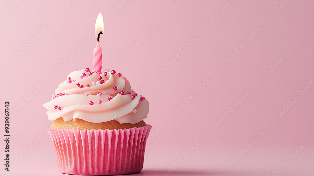 Vanilla cupcake with cream and lit candle on pink background. Copy space. Vanilla cupcake with cream and lit candle on pink background. Copy space.