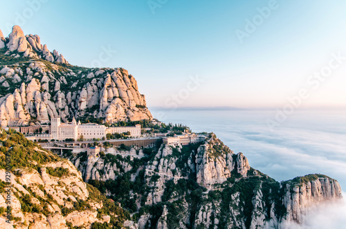 Montserrat mountain range and monastery landscape bathed in a sea of pastel clouds