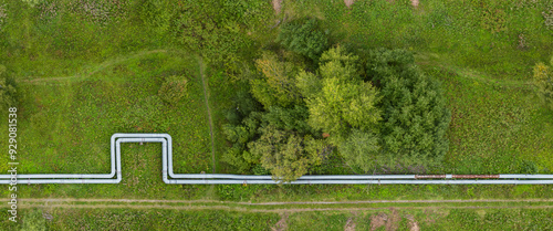Aerial View of Pipeline Cutting Through Green Field and Trees