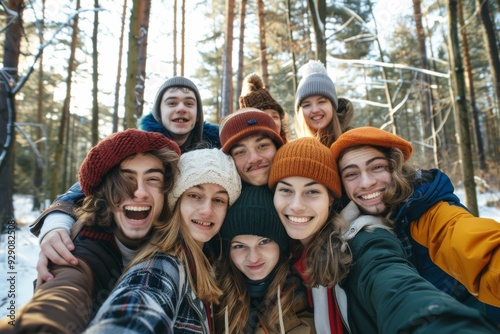 A group of friends huddles together in a snowy forest, their knitted winter hats adding color and warmth as they share wide smiles and a sense of joyful togetherness.