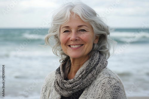 Happy elderly woman standing by the ocean