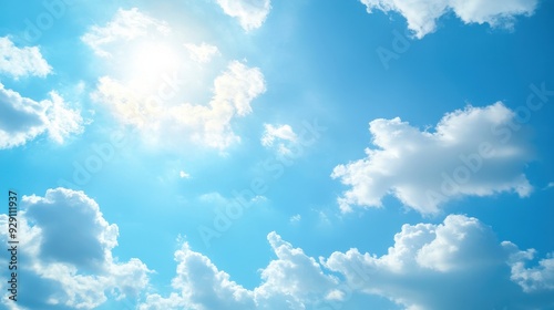 A bright blue sky filled with fluffy white clouds and sunlight.