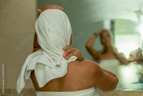 A woman's personal care after a shower. Watch as you wrap yourself in a soft towel, gently pat your skin dry and nourish it with luxurious creams. Experience the ultimate in relaxation.