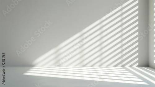 Sunlight filters through window blinds, casting striped shadows across a blank white wall, creating a calm and serene atmosphere in the room