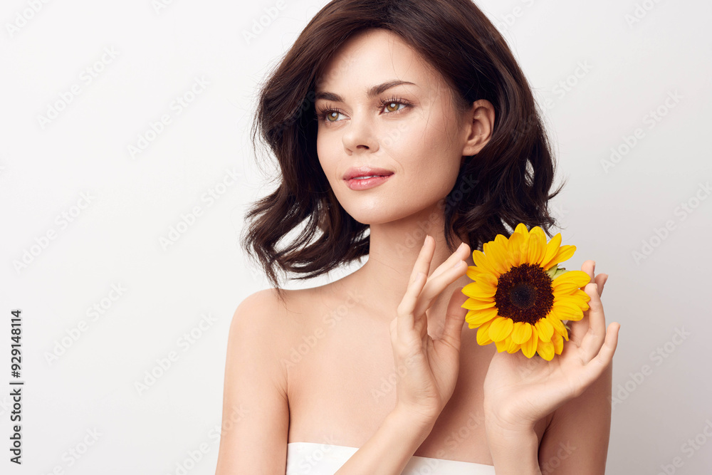 Beautiful young woman holding a sunflower on a white background Beautiful young woman holding a sunflower on a white background