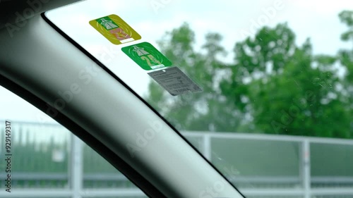 May 15, 2024, Switzerland, Autobahn. Close-up of a man's hands applying a sticker or vignette to a windshield to pay for toll roads, autobahns in Austria. Road toll, vignettes in Austria.
