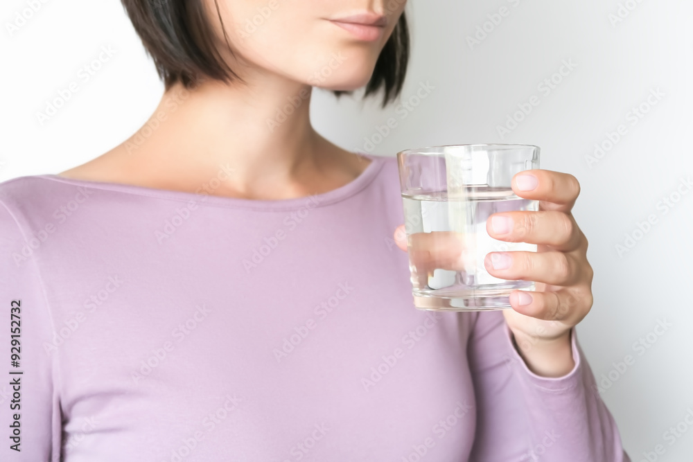 a woman holds a glass of water in her hand and is going to drink it a woman holds a glass of water in her hand and is going to drink it