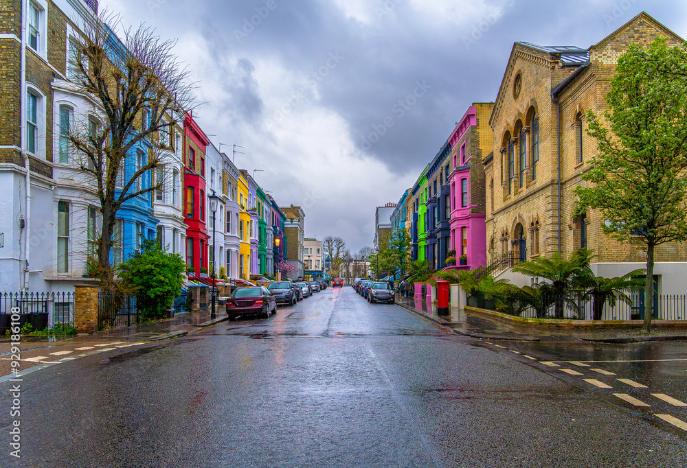 Rainy day in the Notting Hill neighborhood, on Lancaster Road, the legendary street of colorful Victorian-style houses with the reflection of the colors of the houses on the asphalt of the street. Rainy day in the Notting Hill neighborhood, on Lancaster Road, the legendary street of colorful Victorian-style houses with the reflection of the colors of the houses on the asphalt of the street.