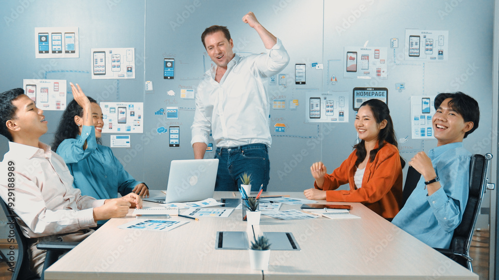 Obraz premium Diverse business team celebrate successful project by clapping hands and raising arm in the air. Group of happy corporate businesspeople smiling while sitting in business meeting. Manipulator.