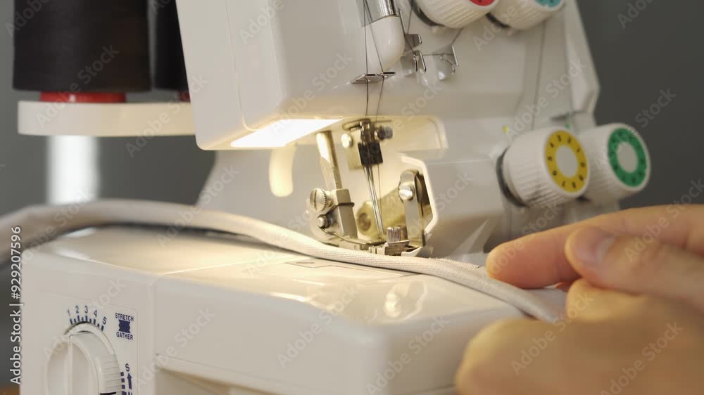 Processing a fabric part on an overlock. Close-up Processing a fabric part on an overlock. Close-up