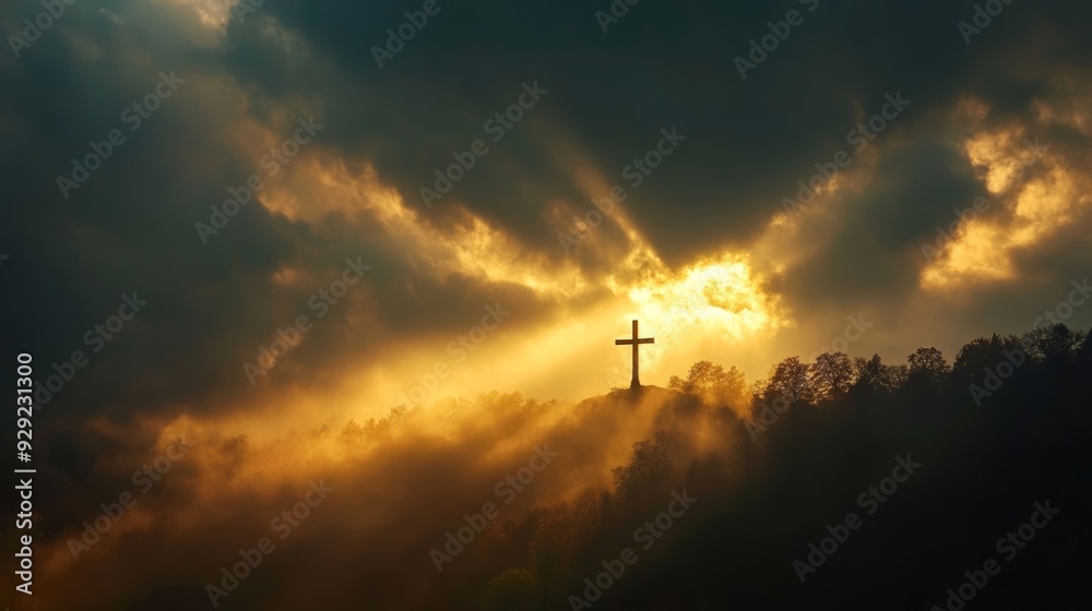 Christian cross standing on a hill with sun shining through clouds Christian cross standing on a hill with sun shining through clouds