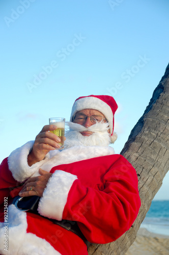 Santa Claus is on vacation on a tropical beach.