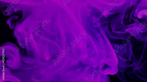 Witness an enchanting swirl of purple smoke gracefully rising against a dark backdrop, creating a mesmerizing visual experience.
