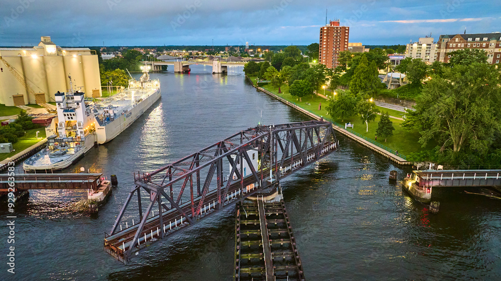 Obraz premium Aerial View of Cargo Ship Grain Silo and Railway Bridge at Twilight
