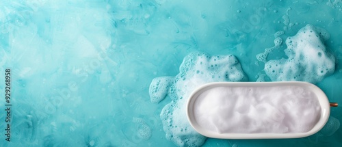  A white soap dish atop a blue-green wall, bearing bubbly mounds of soap photo