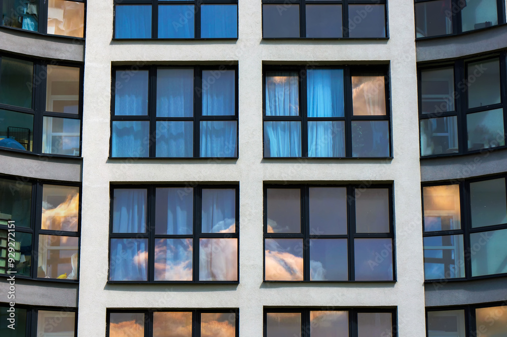 Fototapeta premium Windows with Black Casements on Facade of Modern Building. Sky Reflections in Windows Glass. 