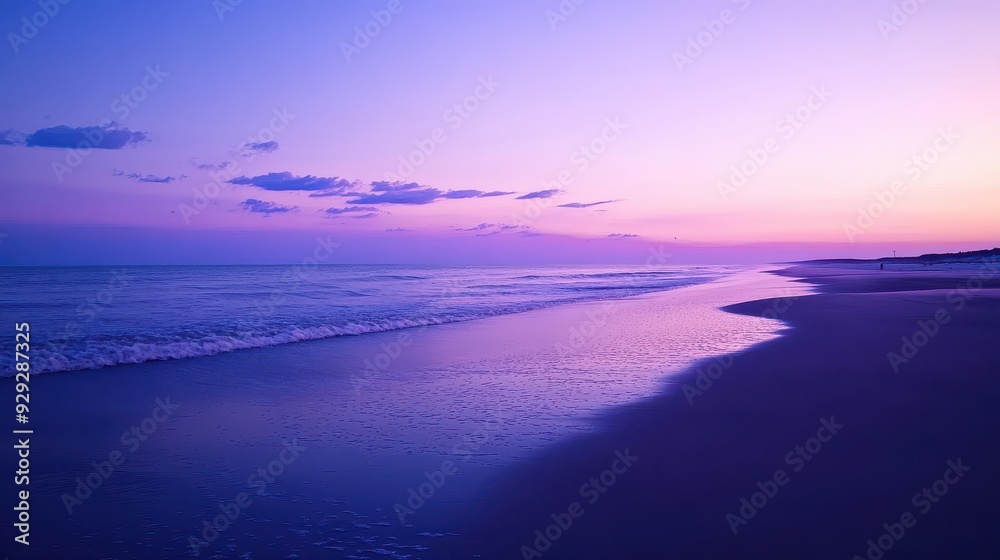 Fototapeta premium A serene beach at sunset with soft waves and a colorful sky.