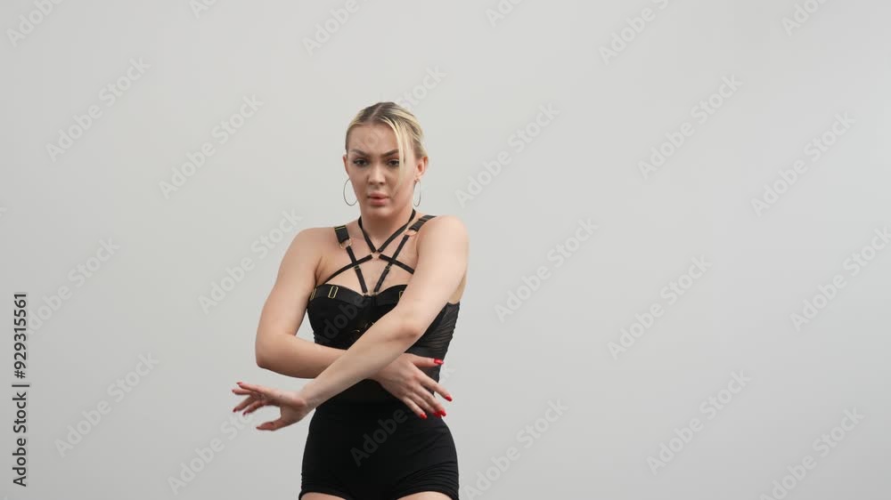 Young woman in black clothes dancing high hills in a white room with a black floor Young woman in black clothes dancing high hills in a white room with a black floor