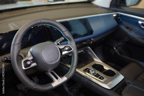 Closeup of a modern car steering wheel with control buttons for technology and convenience