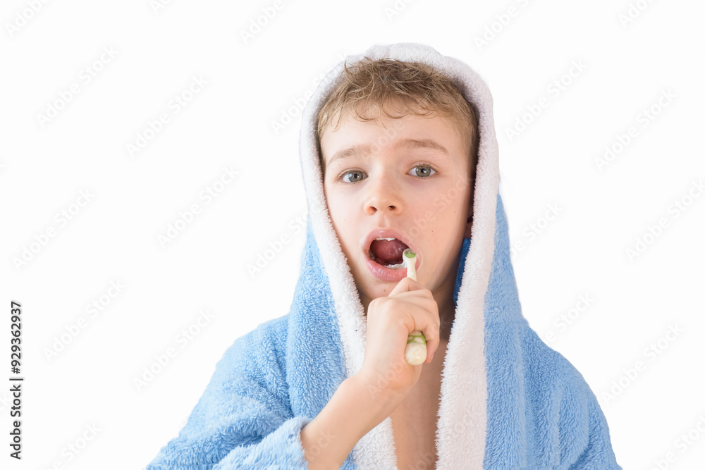 small child, boy in a blue terry robe with a toothbrush on white. A child brushes his teeth. Healthcare and dental care
