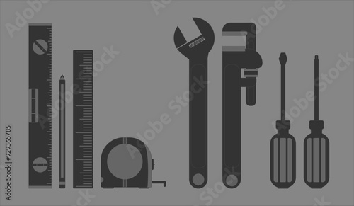 Small set of tools, pencil, screwdrivers, ruler and wrench in dark tones on gray background