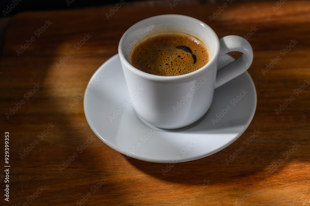 Top down view of a cup of coffee on a wooden table. Top down view of a cup of coffee on a wooden table.