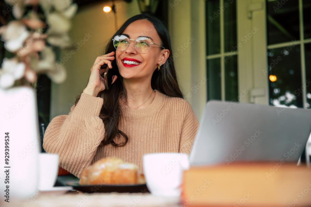 Attractive smiling modern and smart business woman with long black hair in glasses is speaking on her smartphone in terrasse cafe outdoors in good mood and satisfied because of done deal Attractive smiling modern and smart business woman with long black hair in glasses is speaking on her smartphone in terrasse cafe outdoors in good mood and satisfied because of done deal