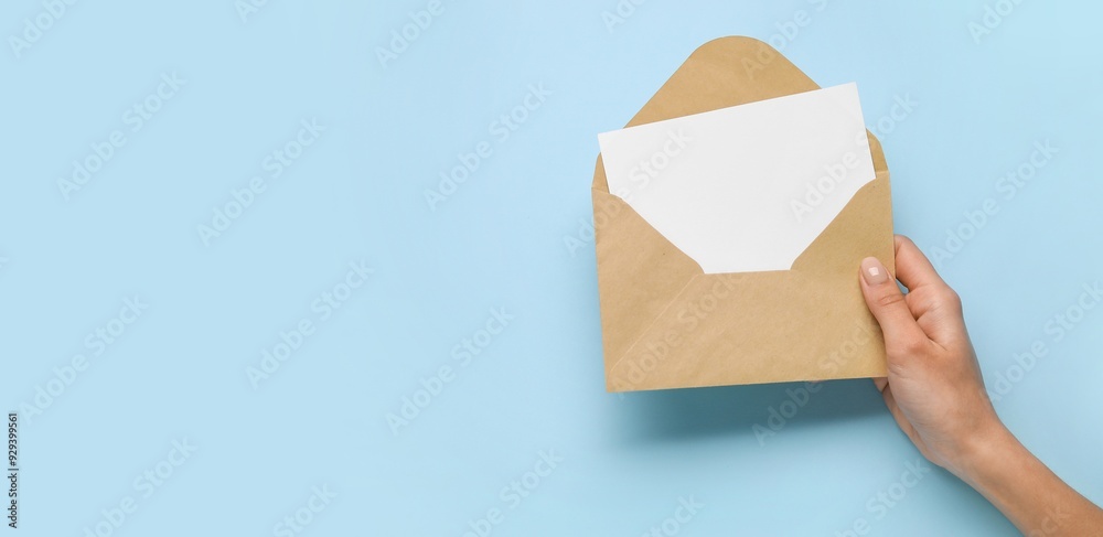 Hand with envelope and blank card on blue background with space for text Hand with envelope and blank card on blue background with space for text