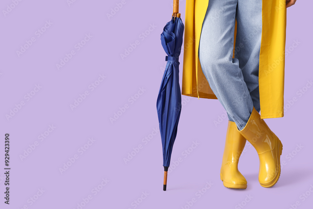 Young woman in raincoat with umbrella on lilac background Young woman in raincoat with umbrella on lilac background