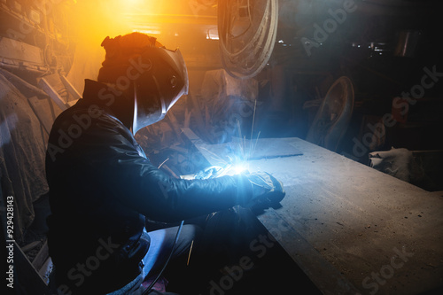 craftsman works in his old garage on an order, metal welding