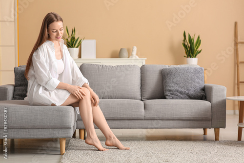 Young barefoot woman sittin...