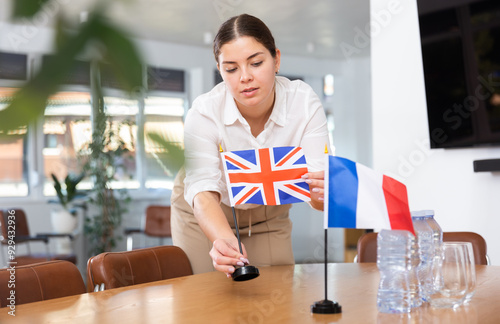 Businesswoman arranging the flags of Great Britanian and France for a presentation and negotiations photo