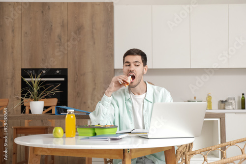 Young man eating lunch whil...