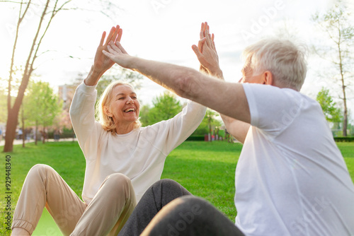Wallpaper Mural elderly couple of seniors man and woman high-five and rejoice at success in the park outdoors, gray-haired grandparents celebrate victory and play sports in nature Torontodigital.ca