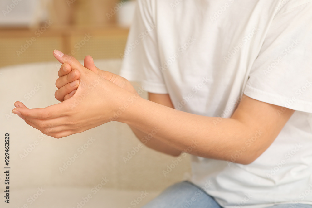 Young woman suffering from pain in finger at home, closeup Young woman suffering from pain in finger at home, closeup