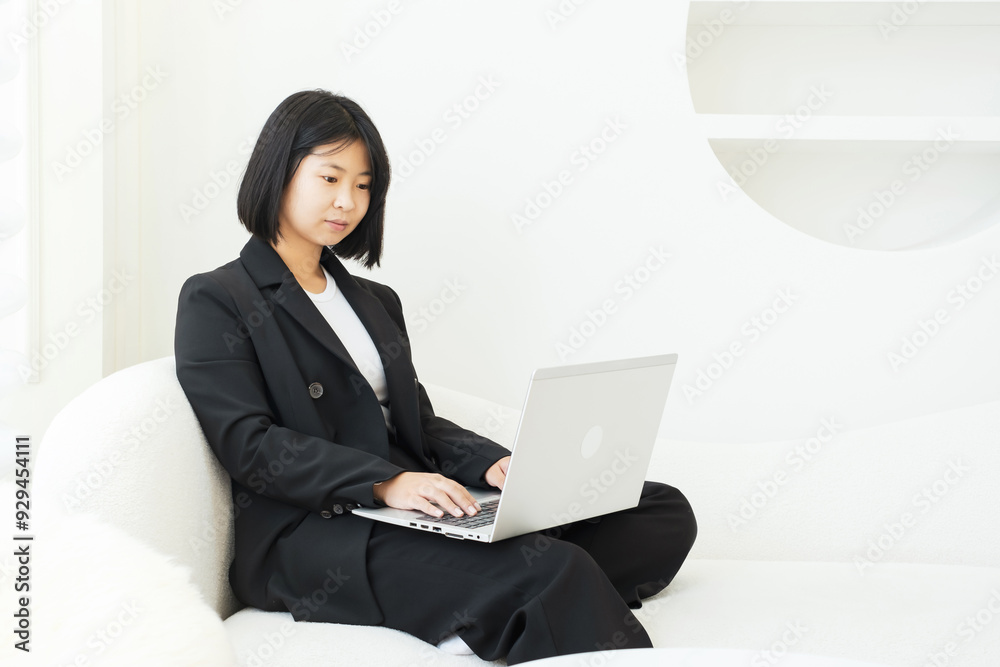 Asian woman typing on laptop in her apartment, work from home concept. Asian woman typing on laptop in her apartment, work from home concept.