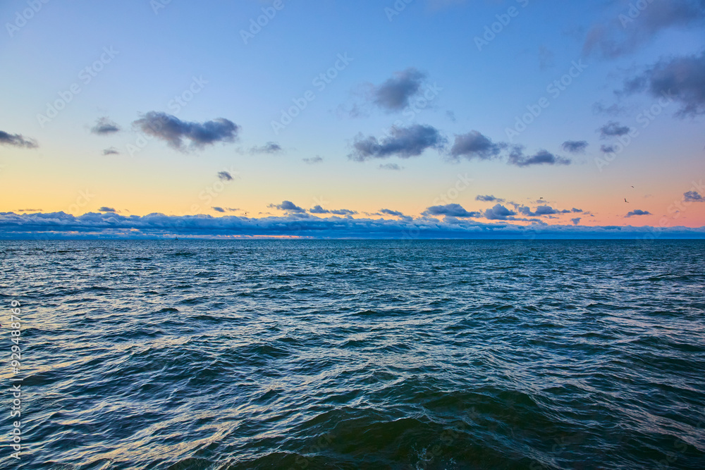 Obraz premium Serene Lake Michigan Sunrise with Gentle Waves from Shoreline Perspective