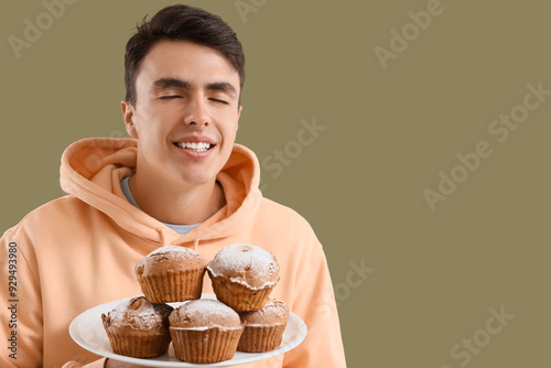 Young man with tasty muffin...